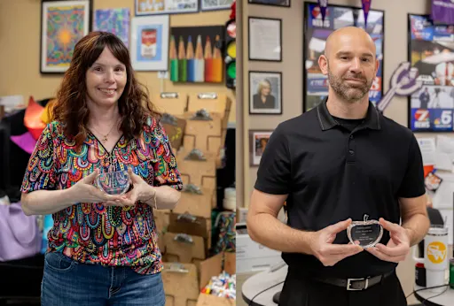 Stephanie Walton and Joshua Ault holding Teacher of the Year Awards