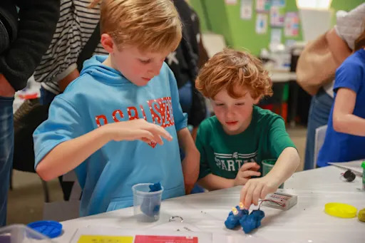 two students experimenting with a small robot