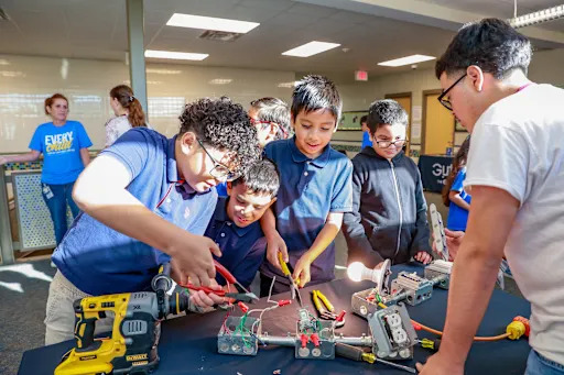 students working with electric wire with pliers