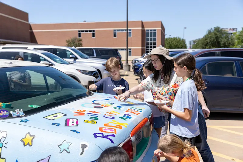 Stephanie Walton and students painting her art car