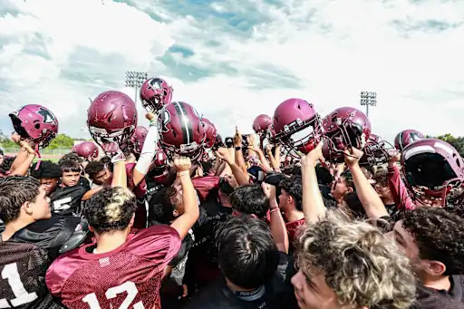northbrook high school football team raising helmets in unison