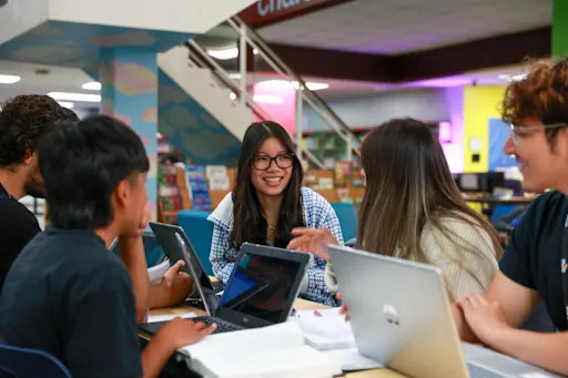 students on laptops in a library