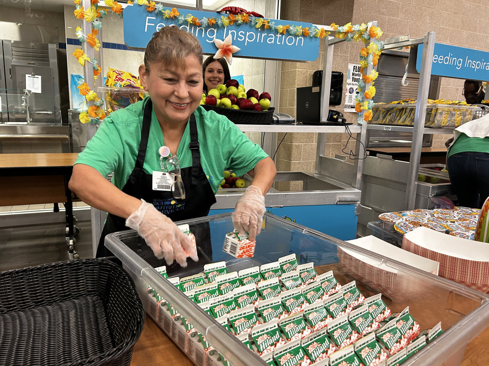 School staff member serving milk