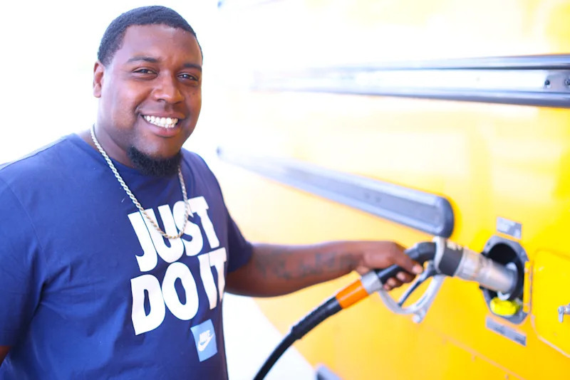Albert Nicholson putting fuel in a school bus