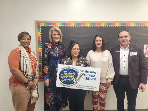 Cristina Espinoza accepting a sign reading "I'm driving success in SBISD!"