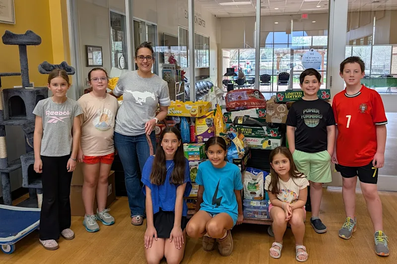 students standing in front of donated pet food