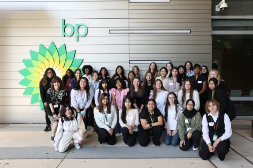 group of girls posed in front of the BP logo