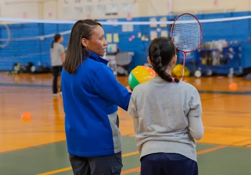 Chenique Whitney with a student in the gym