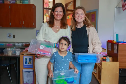 people holding school supplies boxes