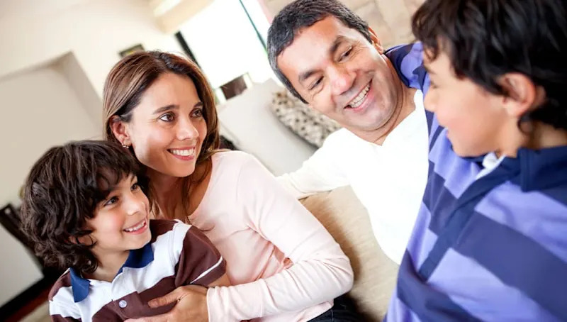 two parents with two kids smiling
