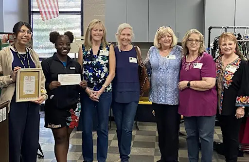Members of the 1974 Spring Woods graduating class  handing two Spring Woods  students a check