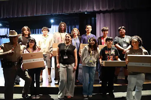 students posed on a stage