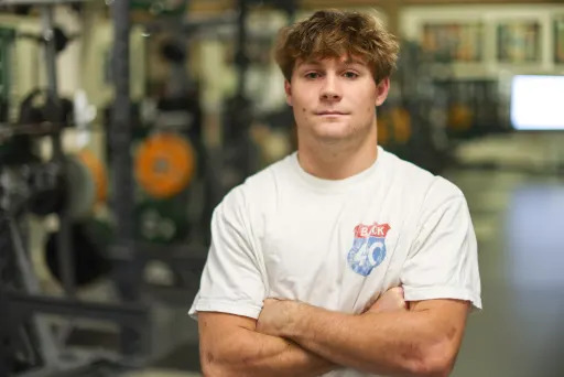 Parker Johnson proudly crossing his arms in the weight room