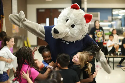 students hugging timberwolf mascot