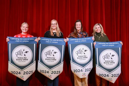 four women holding up banners celebrating high PTA membership