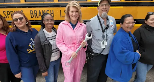 Dr Blaine with transportation professionals holding a wrench