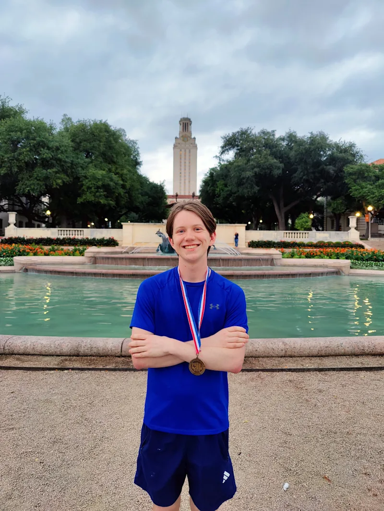 Conrad Slot in front of the UT Auston clock tower wearing a UIL medal.