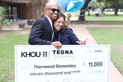 Thornwood principal Sandra Houston accepting a large novelty check for $11,000 addressed to Thornwood Elementary