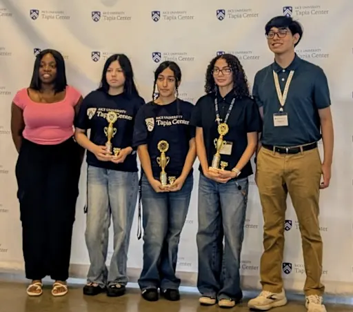 students standing with trophies