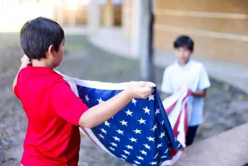 two sherwood elementary students folding the united states' flag