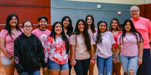 Northbrook High School volleyball and their coach, all wearing pink