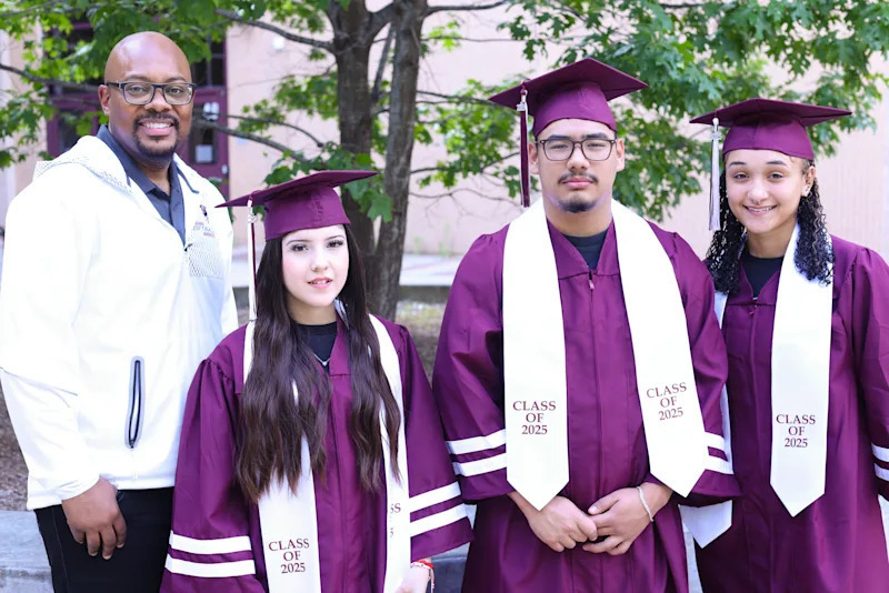 Principal HP Hyder III and three students in full graduation attire