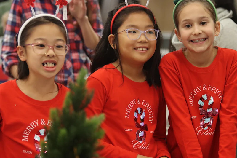 three students in festive shirts smiling