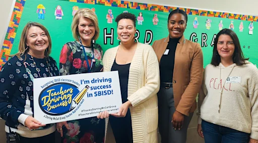 Veronique Hunter being given an award poster reading "I'm driving success in SBISD!"