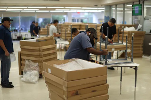 multiple people putting together tables