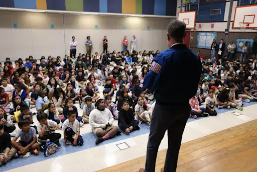 students watching an astronaut present on stage
