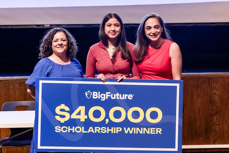 Tairy Araniba holding a sign reading "Big Future $40,000 Scholarship Winner"