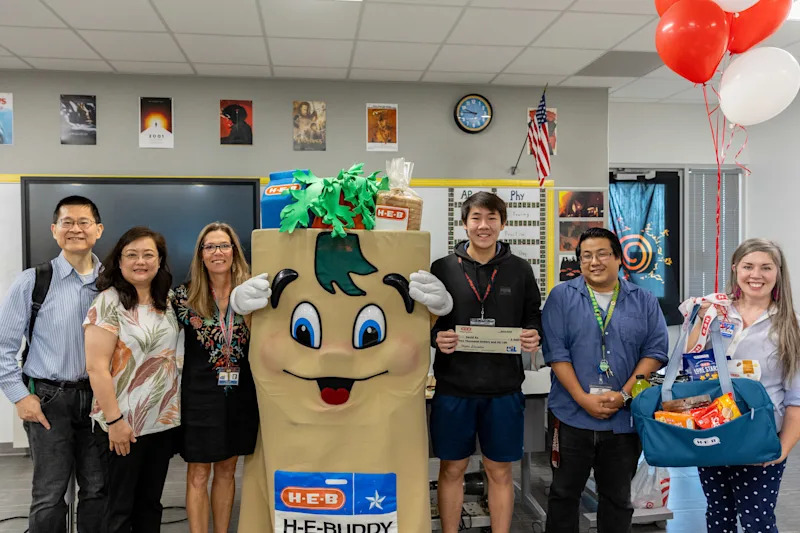 David Xu holding a scholarship check