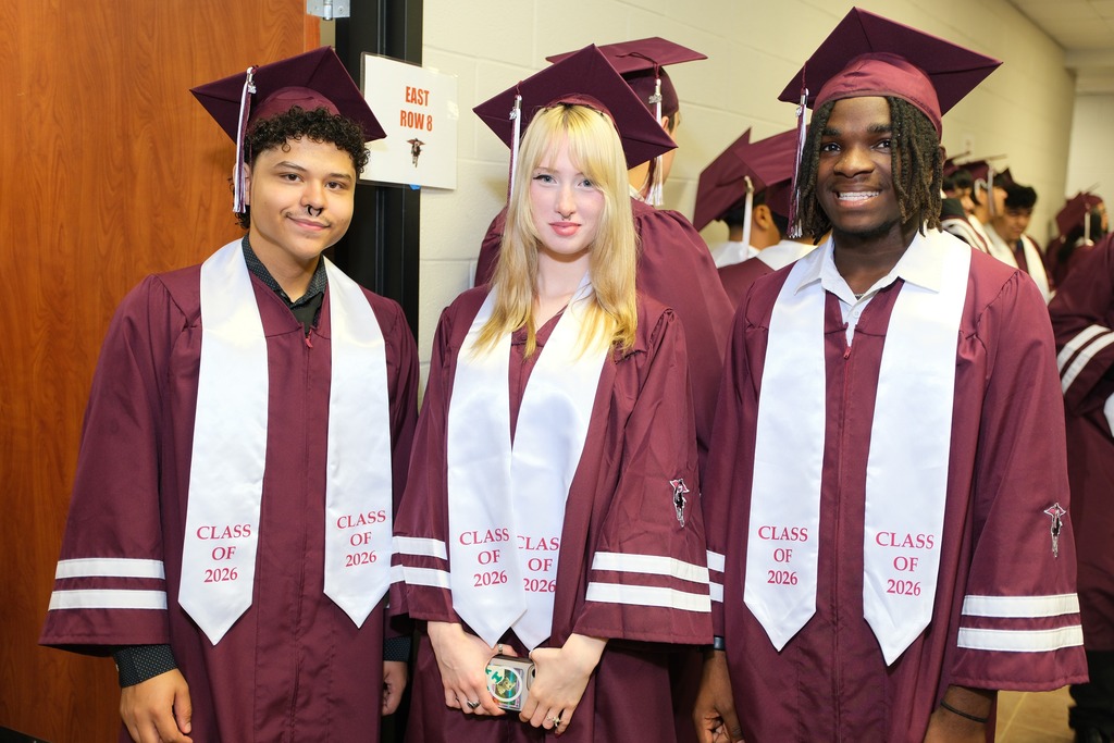 Three students in graduation gowns and caps pose together; each holds a sash with "Class of 2021" printed.