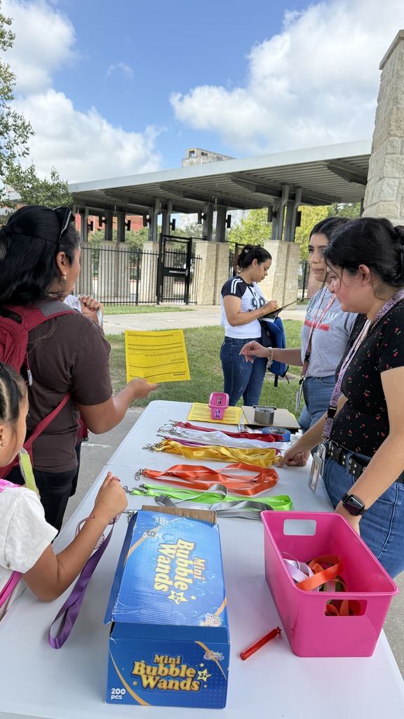 A group of women and a child are at a table with various items, including a box of Bubble Wands.