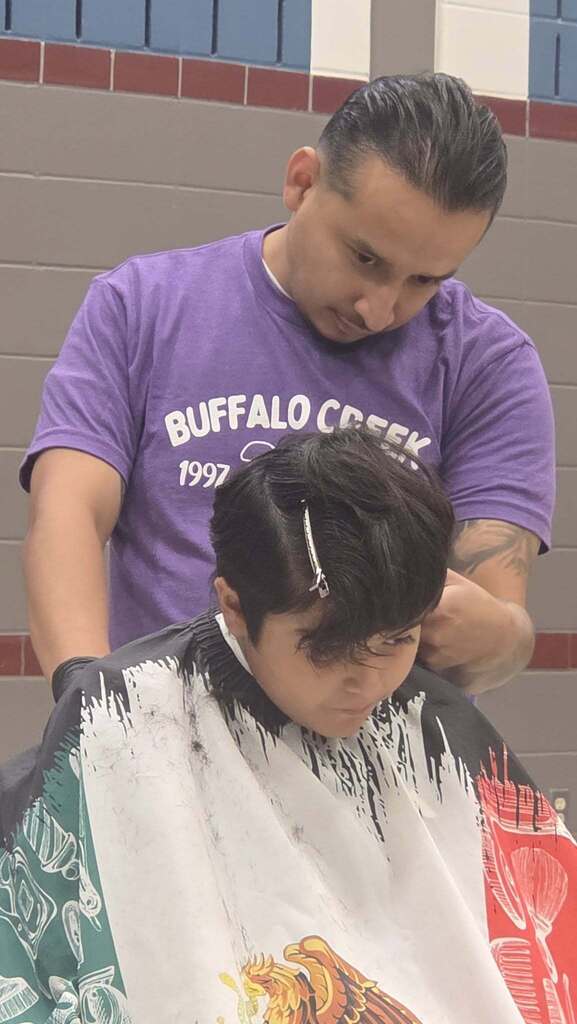 Former Bison Carlos Morales providing haircut for BCE student.
