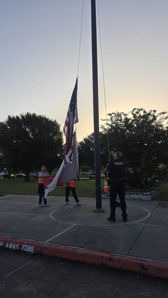 Safety Patrols and School Resource Officer raise the flags.