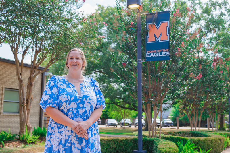 Teacher standing in front of school