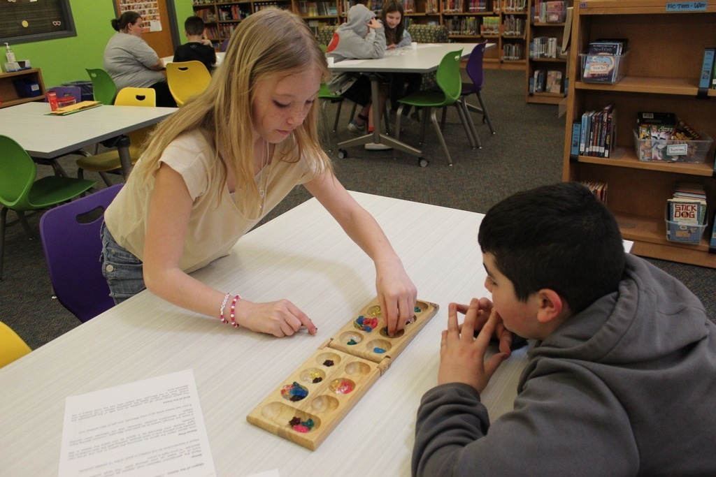 Two students playing mancala