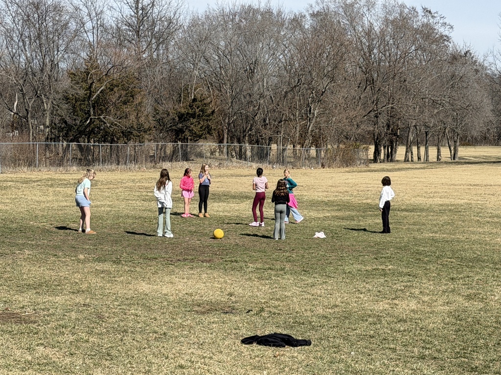 Fourth graders playing soccer on the playground