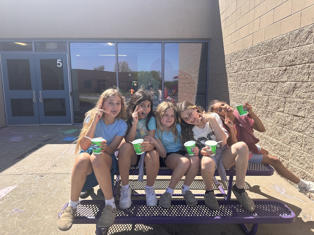 Girls sitting outside eating shaved ice.