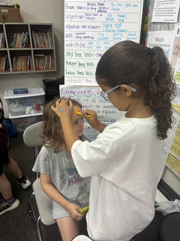 Student applying make up to another student's face.