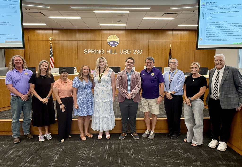 USD 230 Board of Education members and Dr. Link Luttrell posing in the front of the Board room with SHHS theater teacher Adrianna Wendel and two SHHS students 
