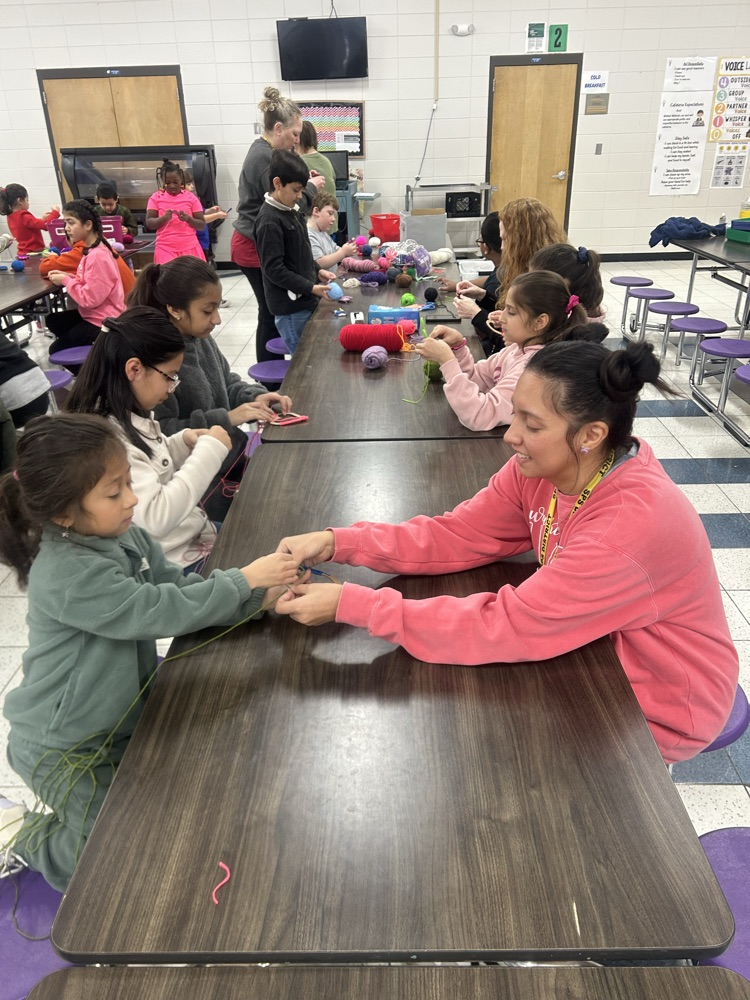 Students crafting hearts out of yarn