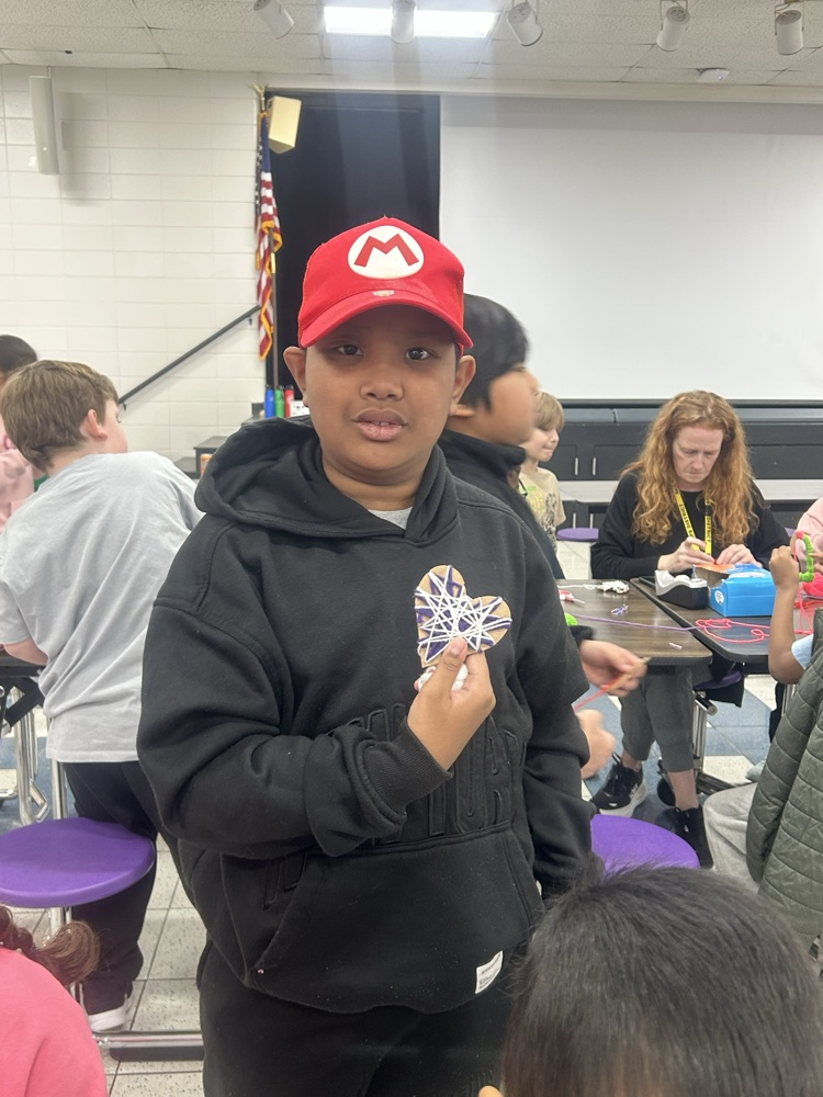 Students crafting hearts out of yarn