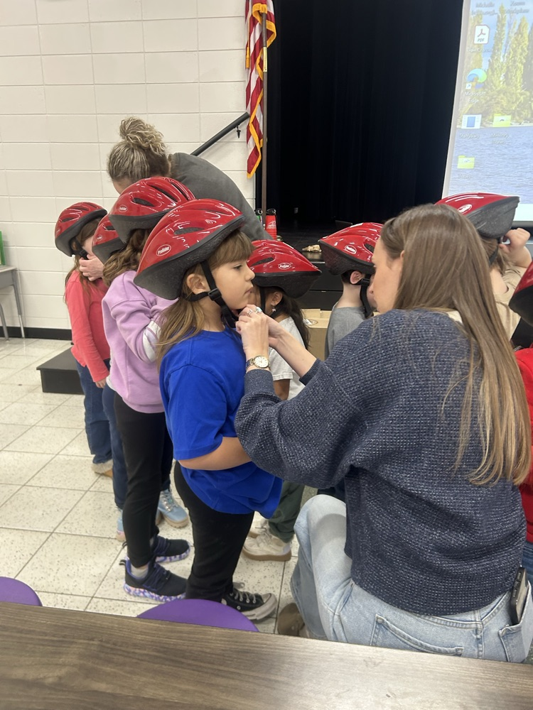 Students putting their helmets on to ride scooters