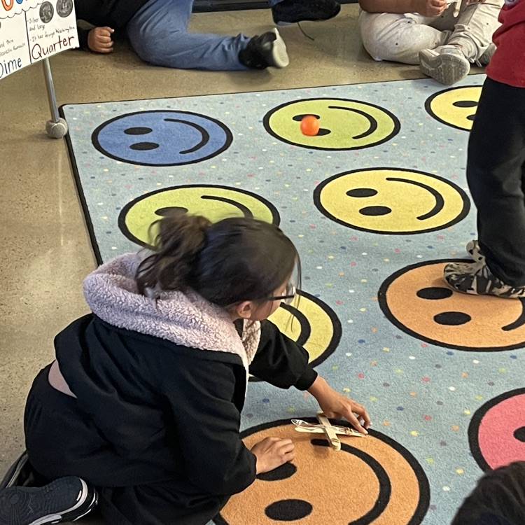 Students launching ping pong balls into a net