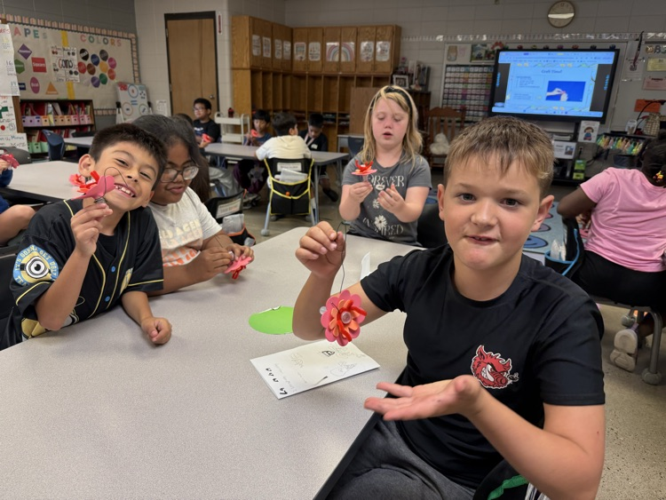 Students holding their crafted hummingbird feeders