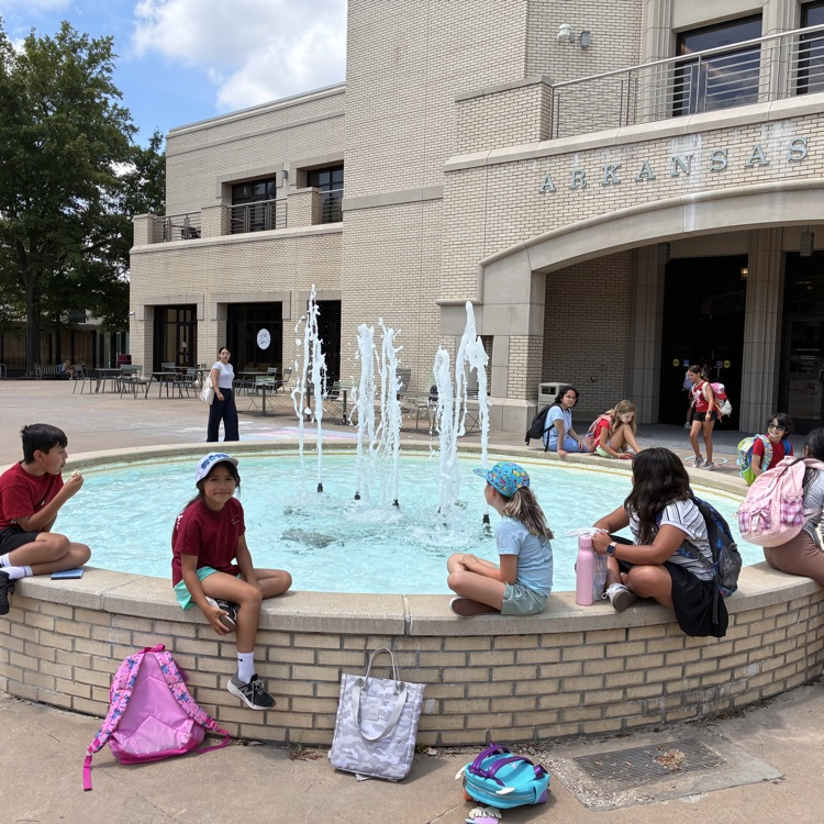 Students sitting around the fountain outside of the student union building at the University of Arkansas