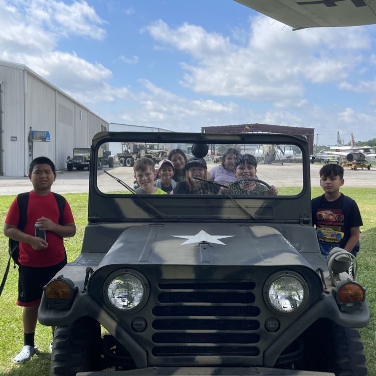 Students sitting in a US military Jeep at the Air and Military Museum  