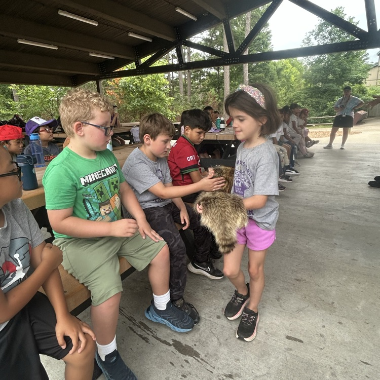 Students petting a Raccoon pelt at Hobbs State Park